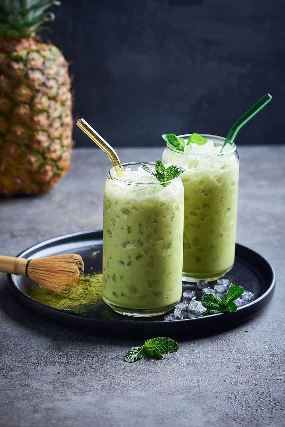 Pineapple matcha mocktail in glasses with colorful straws